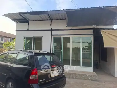 Charming single-story home with modern glass doors and carport in a serene neighborhood.