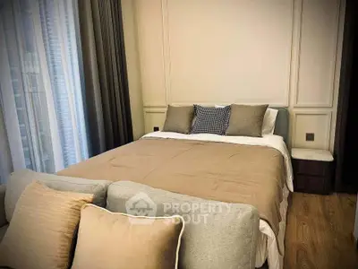 Cozy bedroom with elegant decor and plush bedding in a modern apartment.