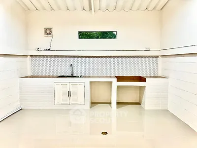 Modern minimalist kitchen with sleek white cabinetry and geometric backsplash