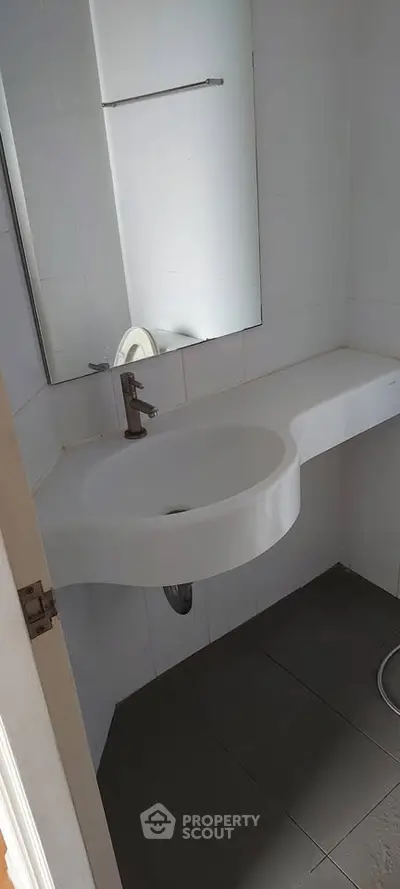 Compact bathroom with modern sink and mirror, ideal for small spaces.