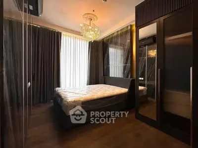 Luxurious bedroom with elegant chandelier and floor-to-ceiling curtains
