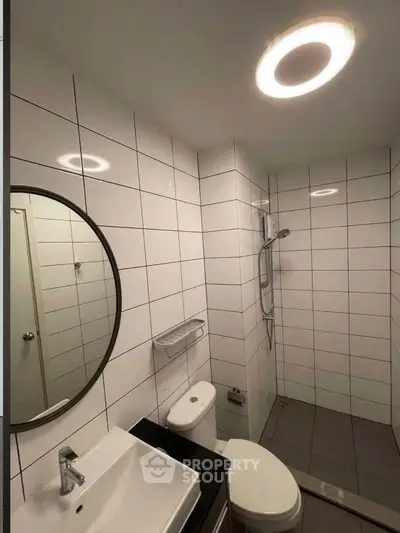 Modern bathroom with sleek tiles and round mirror