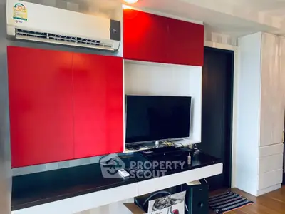 Modern living room with red cabinets and wall-mounted TV