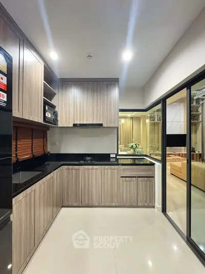 Modern kitchen with sleek cabinetry and open layout leading to living area