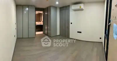 Spacious modern bedroom with sleek built-in wardrobes and air conditioning.