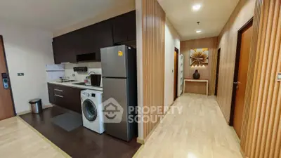 Modern apartment interior with sleek kitchen and hallway, featuring wooden accents and contemporary appliances.