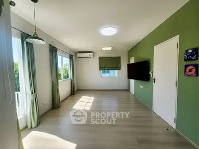 Spacious modern living room with green accents and natural light