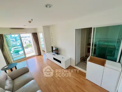 Spacious living room with wooden flooring and city view balcony in modern apartment