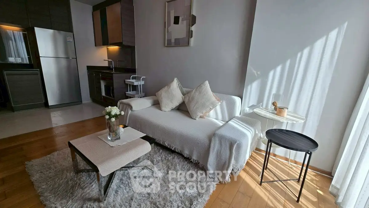 Stylish modern living room with cozy seating and open kitchen layout.