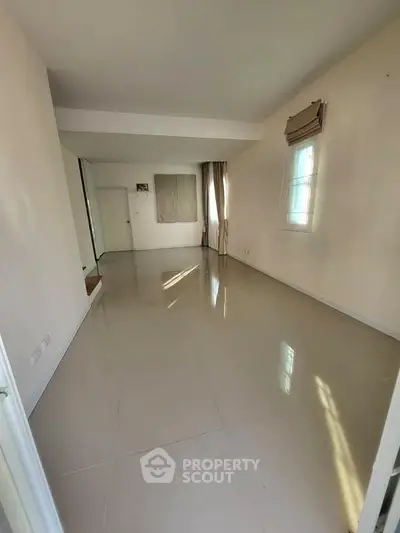 Spacious empty room with large windows and glossy tiled flooring