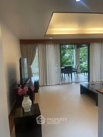 Spacious living room with elegant decor and garden view, perfect for relaxation and entertaining.