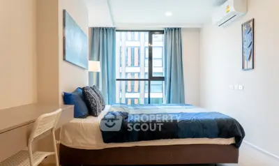 Modern bedroom with stylish decor and large window in a contemporary apartment.