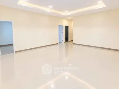 Spacious empty room with glossy tiled flooring and recessed lighting, ideal for customization.