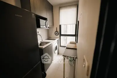 Modern compact kitchen with sleek appliances and natural light