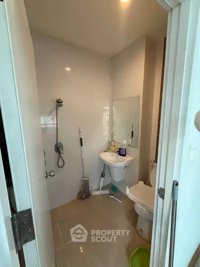 Compact bathroom with shower, sink, and toilet in modern apartment