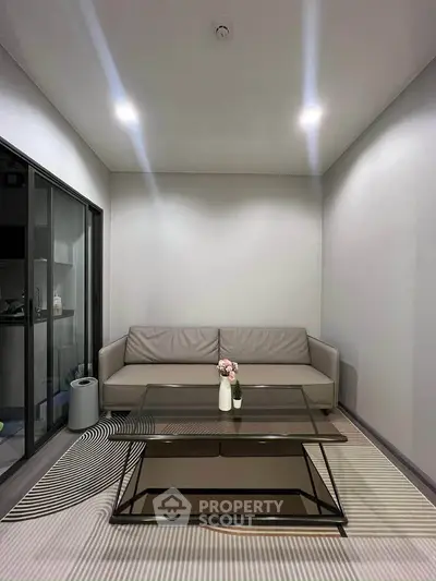 Modern living room with sleek glass coffee table and cozy sofa, perfect for relaxation and entertaining.