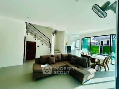 Spacious modern living room with elegant staircase and large windows