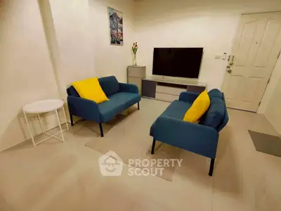 Cozy living room with modern blue sofas and a sleek TV setup, perfect for relaxation and entertainment.