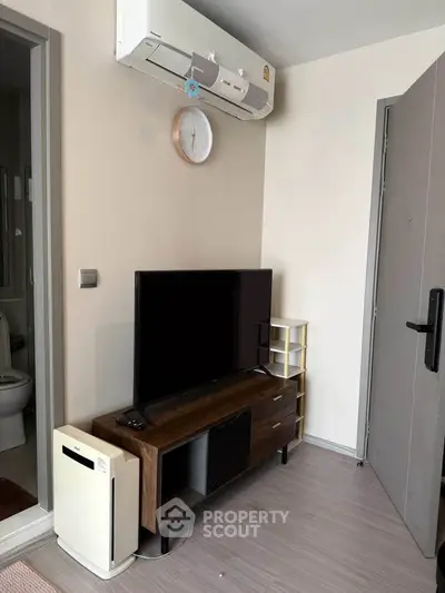 Modern living room with sleek TV stand and air conditioning unit, perfect for cozy urban living.