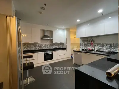 Modern kitchen with sleek white cabinets and stylish backsplash in a contemporary apartment.