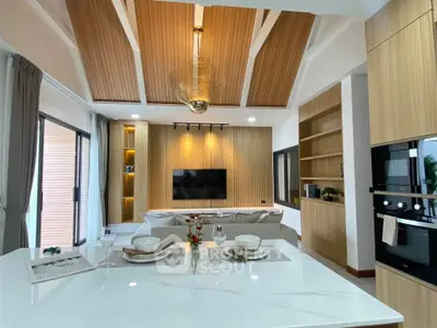 Luxurious modern living room with high wooden ceiling and open kitchen layout, perfect for entertaining.