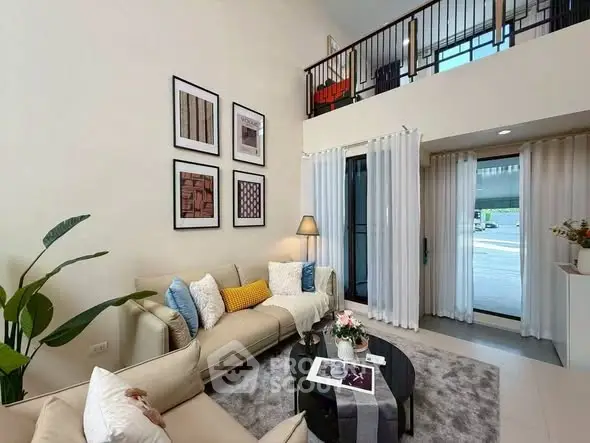 Modern living room with high ceiling and stylish decor in a contemporary home.