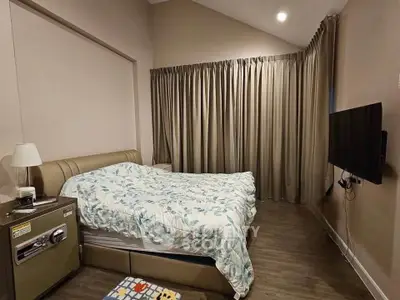 Cozy bedroom with modern decor and wall-mounted TV, perfect for relaxation.