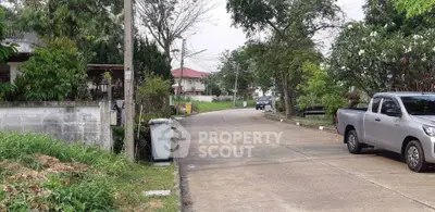 Charming suburban street view with lush greenery and parked vehicles.