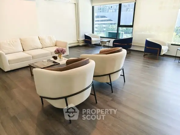 Spacious modern living room with elegant furniture and large windows offering city views.