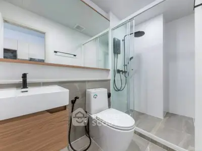 Modern bathroom with sleek design, featuring a glass shower and contemporary fixtures.