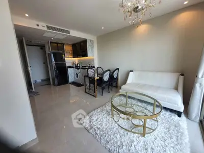 Luxurious open-plan living room with elegant chandelier and modern kitchen.