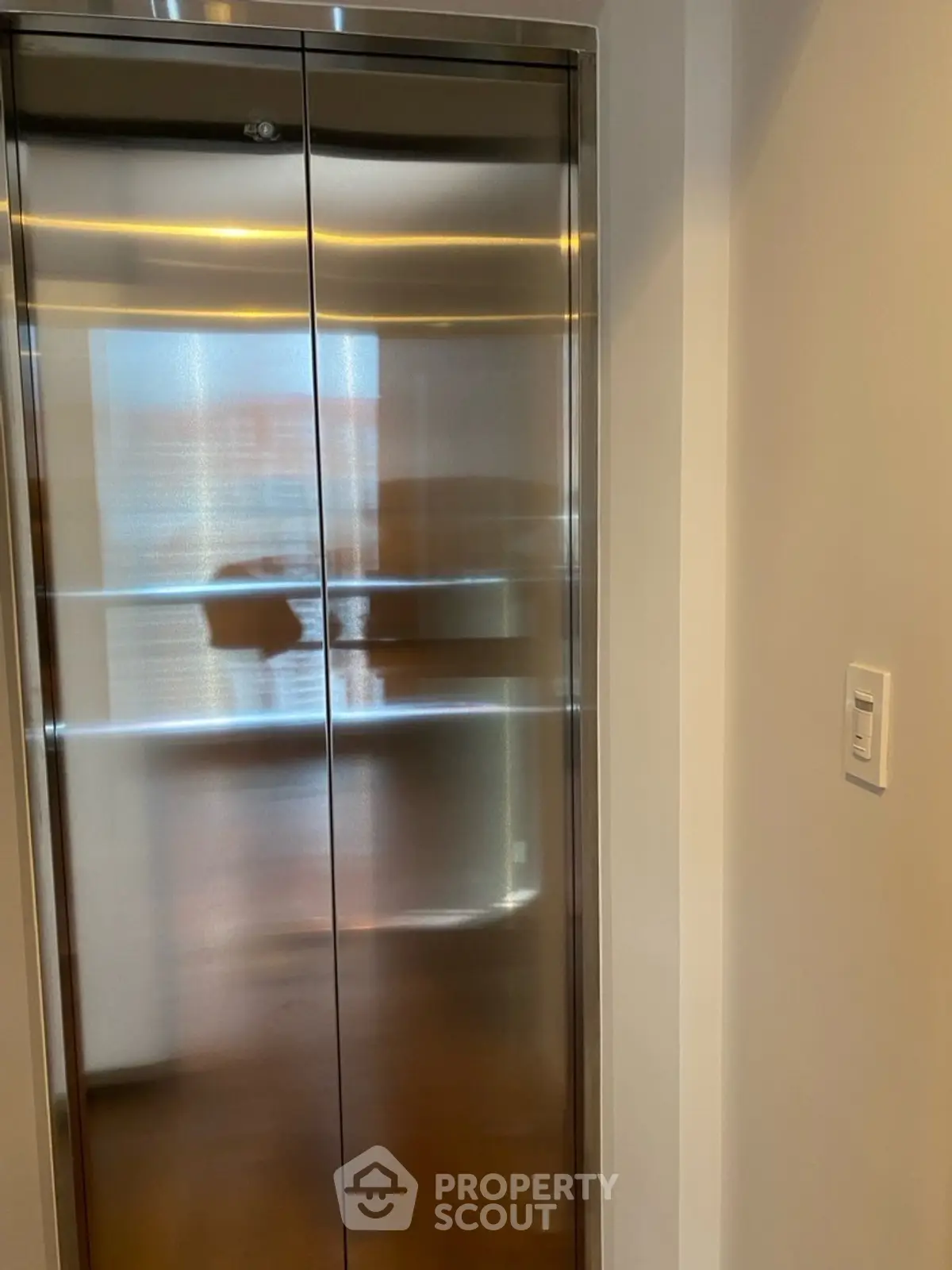 Modern elevator with sleek stainless steel doors in a contemporary building.