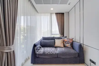 Modern living room with large windows and stylish sofa in a bright apartment.