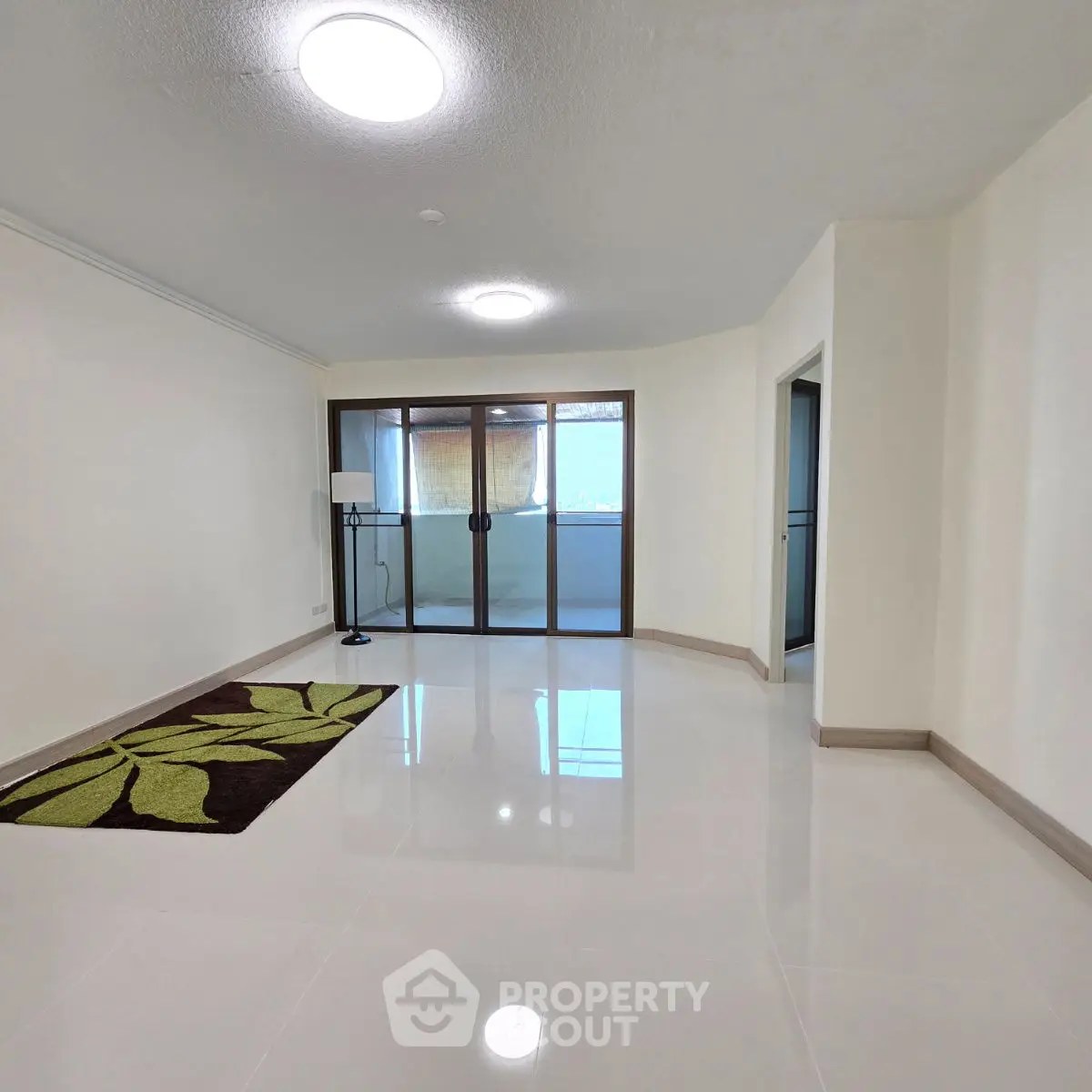 Spacious living room with modern lighting and balcony access