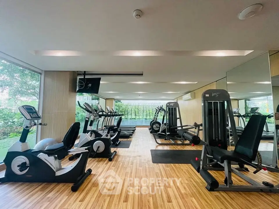 Modern gym with state-of-the-art fitness equipment and large windows for natural light.