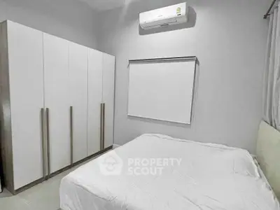 Modern minimalist bedroom with sleek wardrobe and air conditioning