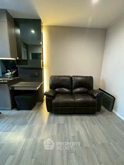 Modern living room with sleek black leather sofa and stylish decor