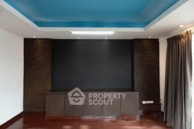 Modern living room with stylish dark accent wall and elegant ceiling design.