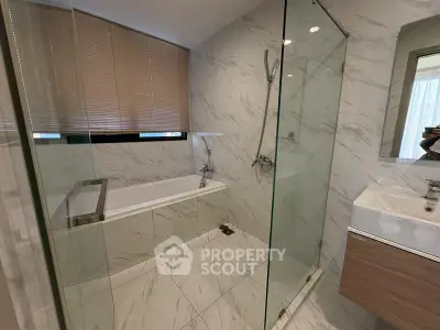 Modern bathroom with glass shower and marble tiles