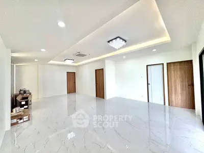Spacious modern living room with elegant lighting and glossy marble flooring.