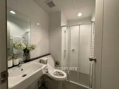 Modern bathroom with glass shower and elegant fixtures in a contemporary apartment.