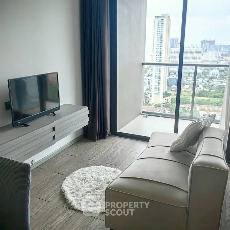 Modern living room with city view, sleek furniture, and large windows for natural light.