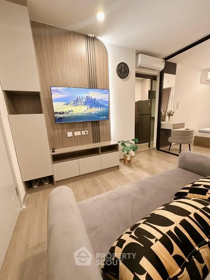 Modern living room with stylish decor and wall-mounted TV in a cozy apartment.