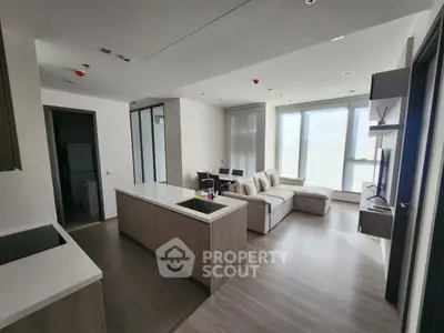 Modern open-layout living room with sleek kitchen island and cozy seating area.