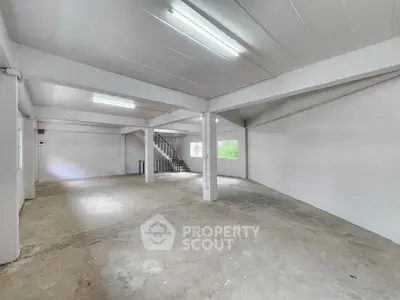 Spacious open-plan industrial space with high ceilings and natural light, ideal for versatile use.