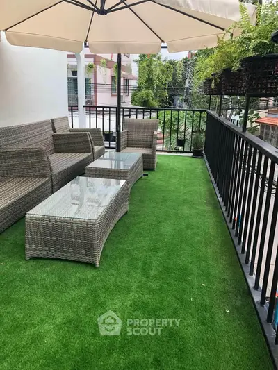 Charming balcony with cozy seating and lush greenery, perfect for relaxation and outdoor enjoyment.