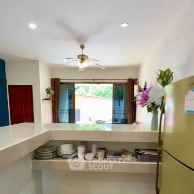 Spacious kitchen with open layout and modern appliances, featuring a view of the garden through large windows.