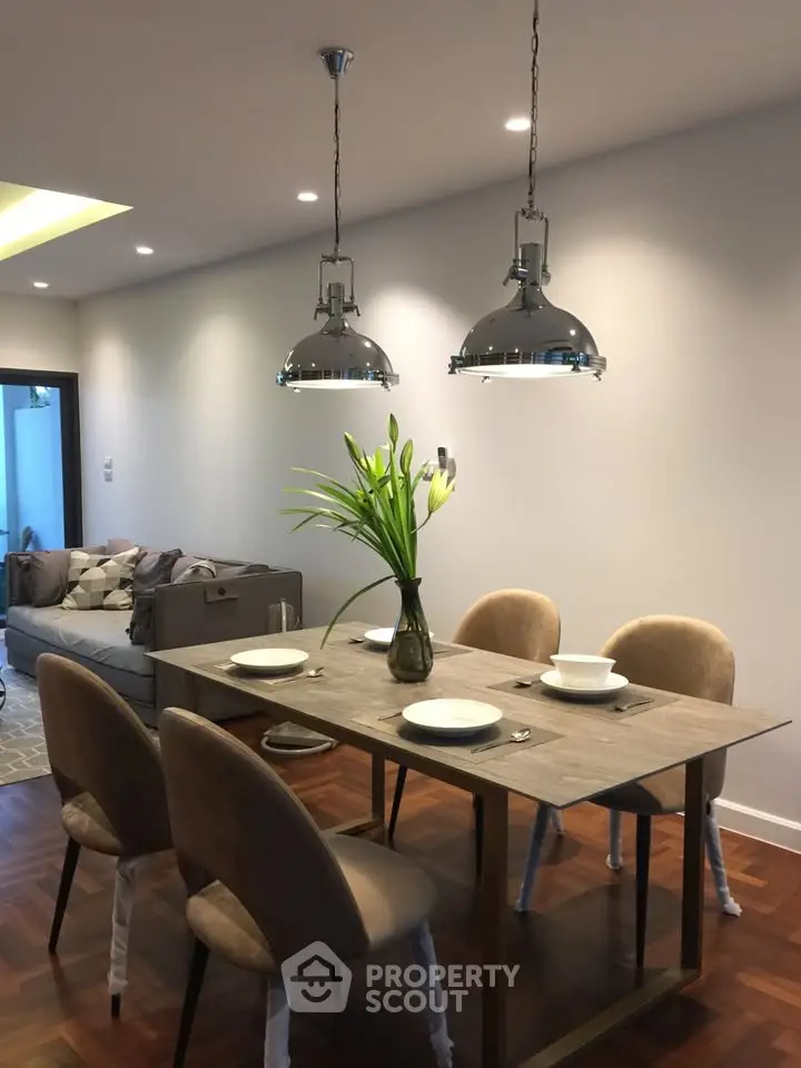 Elegant dining area with modern lighting and cozy seating in a stylish apartment.