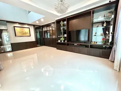 Spacious living room with elegant chandelier and built-in entertainment center