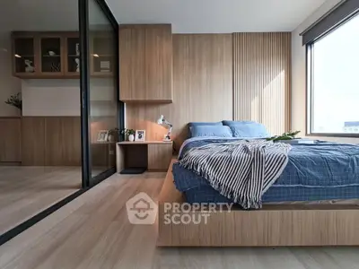 Modern bedroom with wooden accents and large window offering natural light